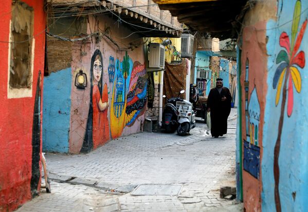 منظر لممر عليه لوحات جدارية رسمتها مجموعة من الرسامين العراقيين الذين تطوعوا لطلاء جدران منازل الأحياء القديمة لتزيين مدينتهم في حي الكاظمية في بغداد، العراق، 30  نوفمبر 2021 - سبوتنيك عربي