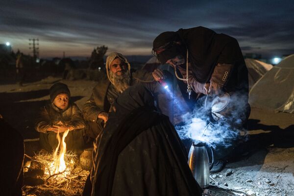 عائلة تحضر الشاي خارج مكتب مديرية الكوارث حيث يقيمون في هرات، أفغانستان، 29 نوفمبر 2021
 - سبوتنيك عربي