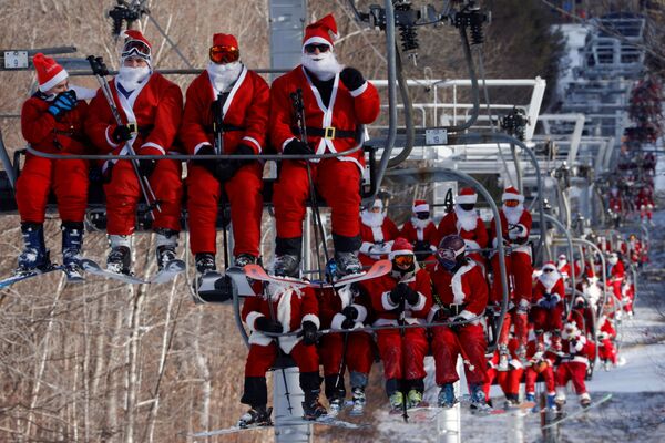 متزلجون يرتدون زي سانتا (بابا نويل) يشاركون في مهرجان سانتا الأحد الخيري في منتجع سانداي ريفر للتزلج في بيثيل، ولاية مين، الولايات المتحدة، 5 ديسمبر 2021 - سبوتنيك عربي