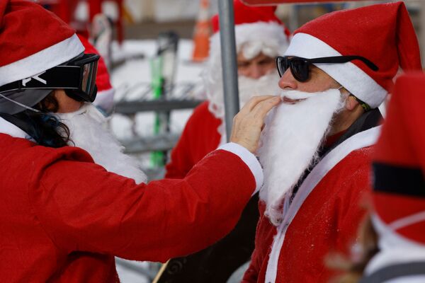متزلجون يرتدون زي سانتا (بابا نويل) يشاركون في مهرجان سانتا الأحد الخيري في منتجع سانداي ريفر للتزلج في بيثيل، ولاية مين، الولايات المتحدة، 5 ديسمبر 2021 - سبوتنيك عربي