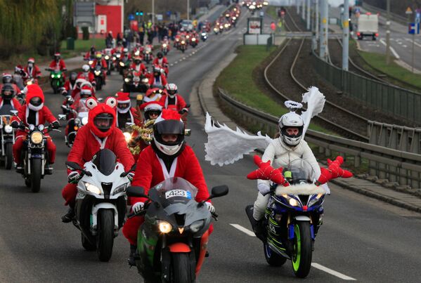 سائق دراجة نارية يرتدي زي ملاك يقود سيارته خلال فعالية سانتا على الدراجات النارية، وهو عرض يهدف إلى تمويل حزم عيد الميلاد والوجبات الساخنة للأطفال المحتاجين، في جدانسك، بولندا، 5 ديسمبر 2021 - سبوتنيك عربي