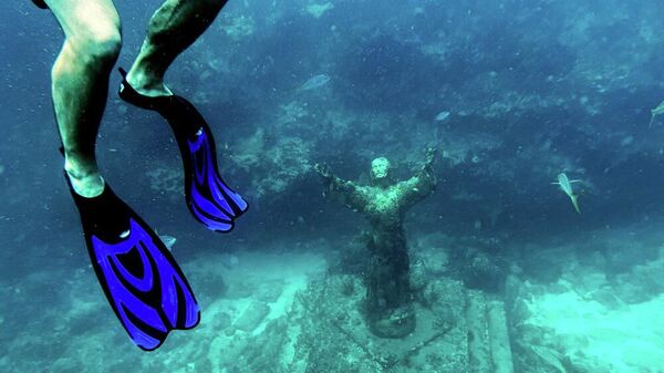 سائح يغطس بالقرب من تمثال مسيح الأعماق محاطا بمرجان ميت على قاع المحيط في مضيق فلوريدا بالقرب من كي لارجو، فلوريدا، أمريكا - سبوتنيك عربي