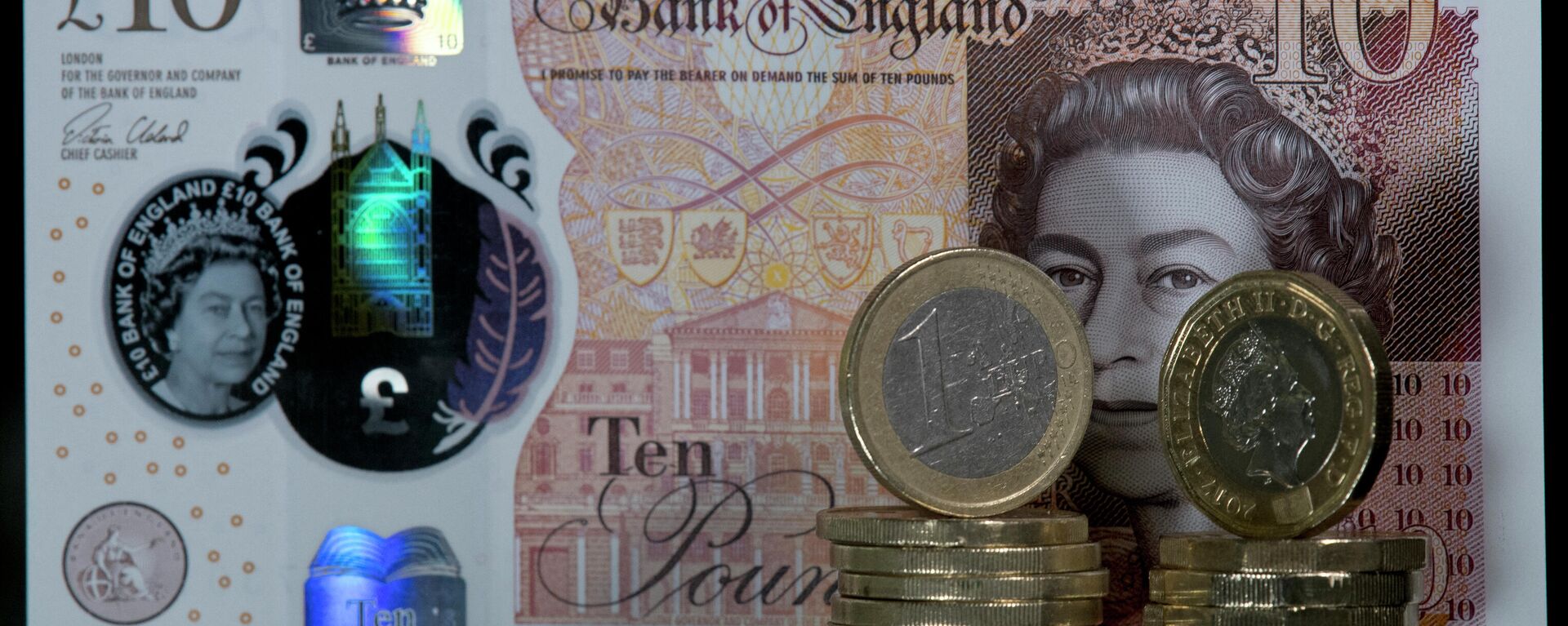 10 جنيهات إسترلينية أمامها عملات معدنية فئة جنيه إسترليني واحد ويورو واحد - سبوتنيك عربي, 1920, 25.04.2022