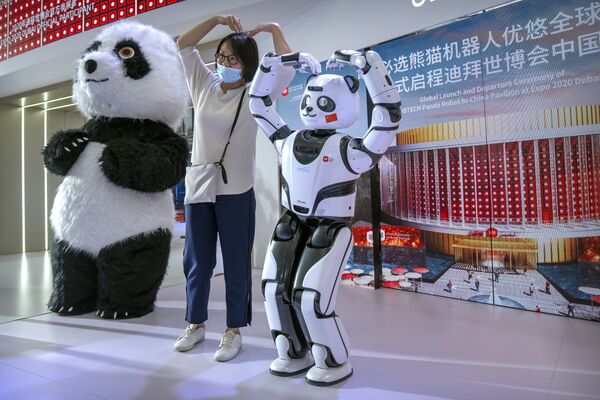 زائر يقف لالتقاط صورة مع باندا آلية في عرض من صانع الروبوتات الصيني UBTech في إطار مؤتمر الروبوتات العالمي في بكين، 11 سبتمبر 2021. - سبوتنيك عربي