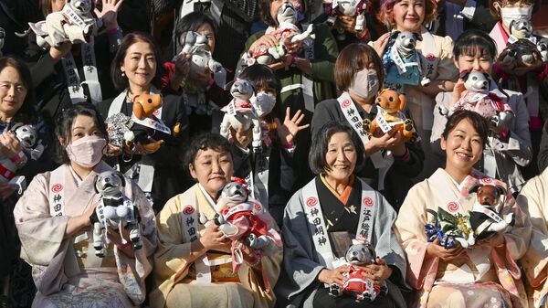 مُلاك الروبوت الأليف Aibo من شركة سوني يقفون لالتقاط صورة تذكارية خلال حدث حتفلي بمناسبة عيد ميلاد Aibo الثالث، طوكيو، اليابان 12 نوفمبر 2021. - سبوتنيك عربي