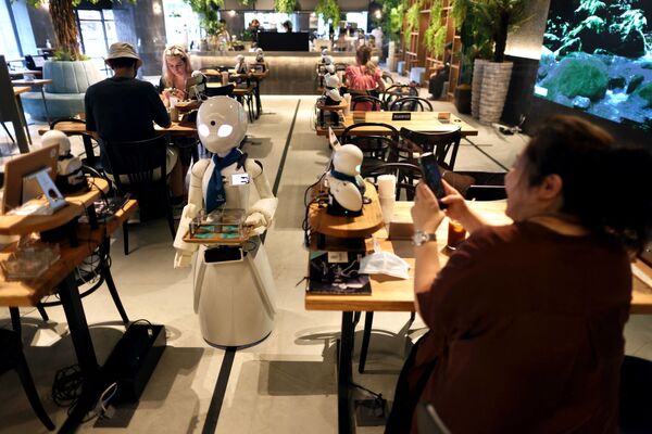 في هذه الصورة التي التقطت في 17 أغسطس 2021، يحضر نادل آلي المشروبات للزبائن في Dawn مقهى داون كافي في طوكيو اليابانية. - سبوتنيك عربي
