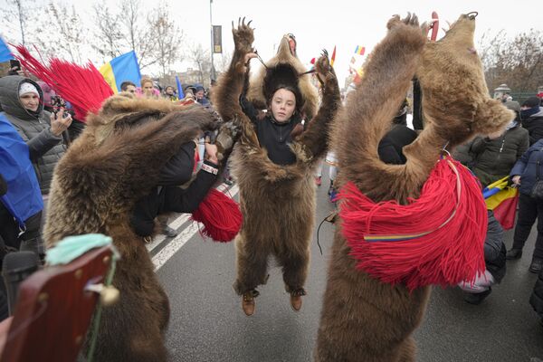 تجمع متظاهرو الممر الأخضر لمكافحة كوفيد-19 خارج قصر البرلمان وانضم إليهم مجموعة من الأشخاص يرتدون فراء الدب ويؤدون طقوس رأس السنة الجديدة في بوخارست، رومانيا، 21 ديسمبر 2021. - سبوتنيك عربي