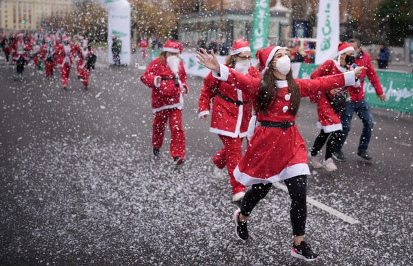 أشخاص يرتدون ملابس سانتا كلوز في سباق خيري لجمع الأموال لمساعدة ضحايا ثوران بركان كومبر فيجا، مدريد، إسبانيا، 19 ديسمبر 2021. - سبوتنيك عربي