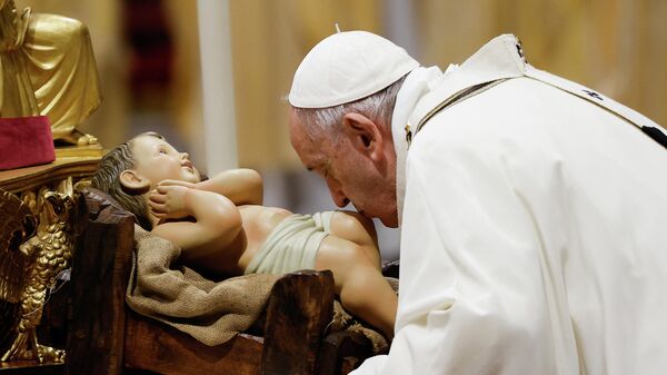البابا فرنسيس الثاني يقبل تمثال الطفل يسوع أثناء احتفاله بالقداس الإلهي ليلة عيد الميلاد في كاتدرائية القديس بطرس بالفاتيكان، 24 ديسمبر/ كانون الأول 2021 - سبوتنيك عربي