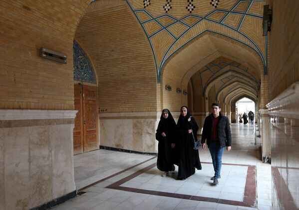 الملاكمة العراقية، بشرى عبد الزهرة، البالغة من العمر 36 عامًا، تسير مع ابنها وابنتها في &quot;ضريح الإمام علي &quot;بالنجف، العراق ، 24 ديسمبر 2021 - سبوتنيك عربي