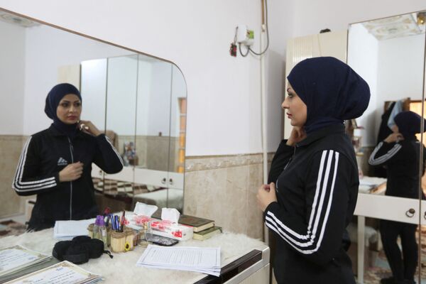 الملاكمة العراقية، بشرى عبد الزهرة، البالغة من العمر 36 عامًا، تجهز نفسها قبل الذهاب إلى التدريب بمنزلها في النجف، العراق ، 24 ديسمبر 2021 - سبوتنيك عربي
