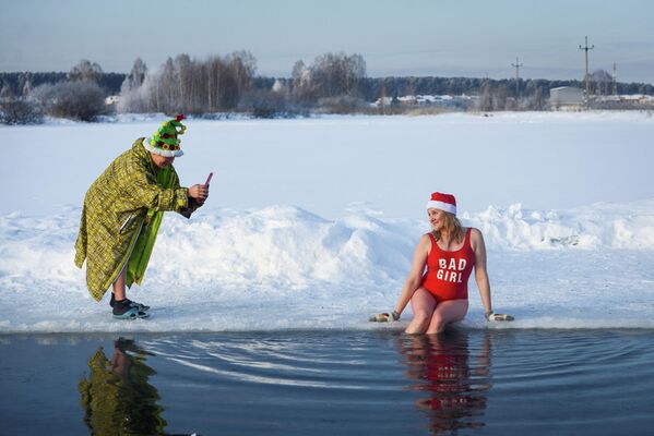 أعضاء نادي محلي للسباحة الشتوية يحتفلون ببدء موسم السباحة الشتوية في بحيرة بويارسكويه بضواحي مدينة تومسك الروسية، 26 ديسمبر 2021 - سبوتنيك عربي