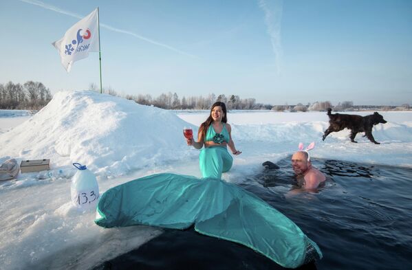 أعضاء نادي محلي للسباحة الشتوية يحتفلون ببدء موسم السباحة الشتوية في بحيرة بويارسكويه بضواحي مدينة تومسك الروسية، 26 ديسمبر 2021 - سبوتنيك عربي