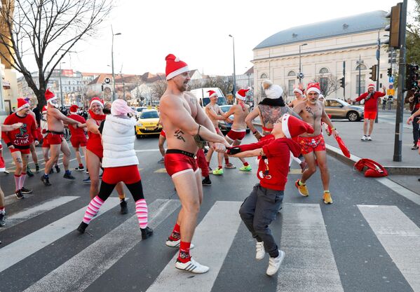 أشخاص يشاركون في سباق سانتا نصف عارٍ في وسط مدينة بودابست، المجر، 12 ديسمبر 2021 - سبوتنيك عربي