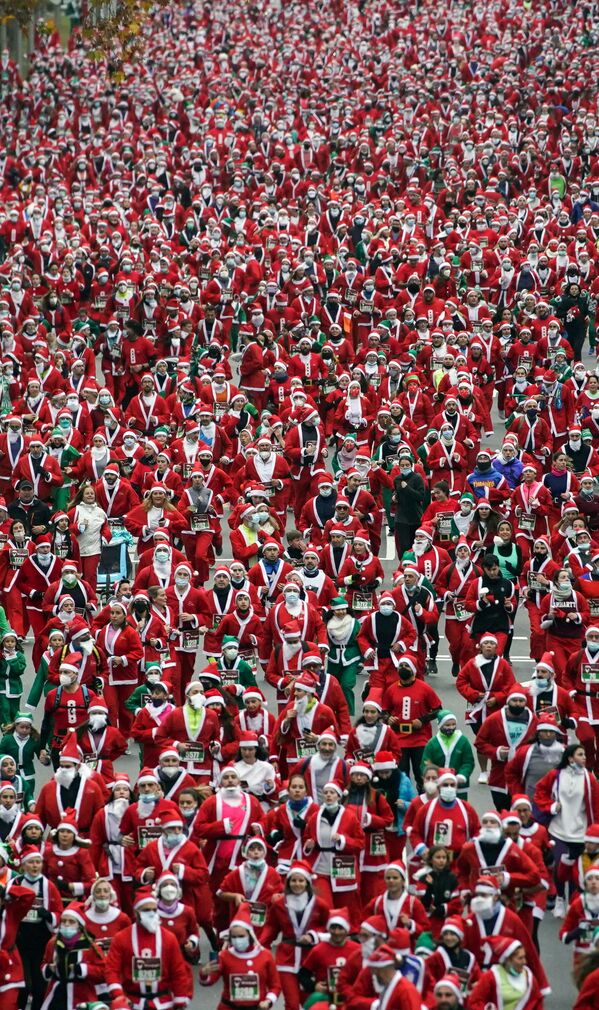 أشخاص يرتدون ملابس بابا نويل يشاركون في سباق خيري لجمع الأموال لمساعدة ضحايا ثوران بركان كومبر فيجا، في مدريد، إسبانيا، 19 ديسمبر 2021. - سبوتنيك عربي