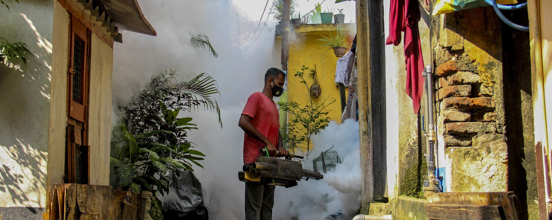 أحد العاملين بالخدمات الصحية يرش المبيدات كإجراء وقائي ضد حمى الضنك التي ينقلها البعوض في كولومبو بسريلانكا 20 ديسمبر 2021 - سبوتنيك عربي, 1920, 18.07.2023