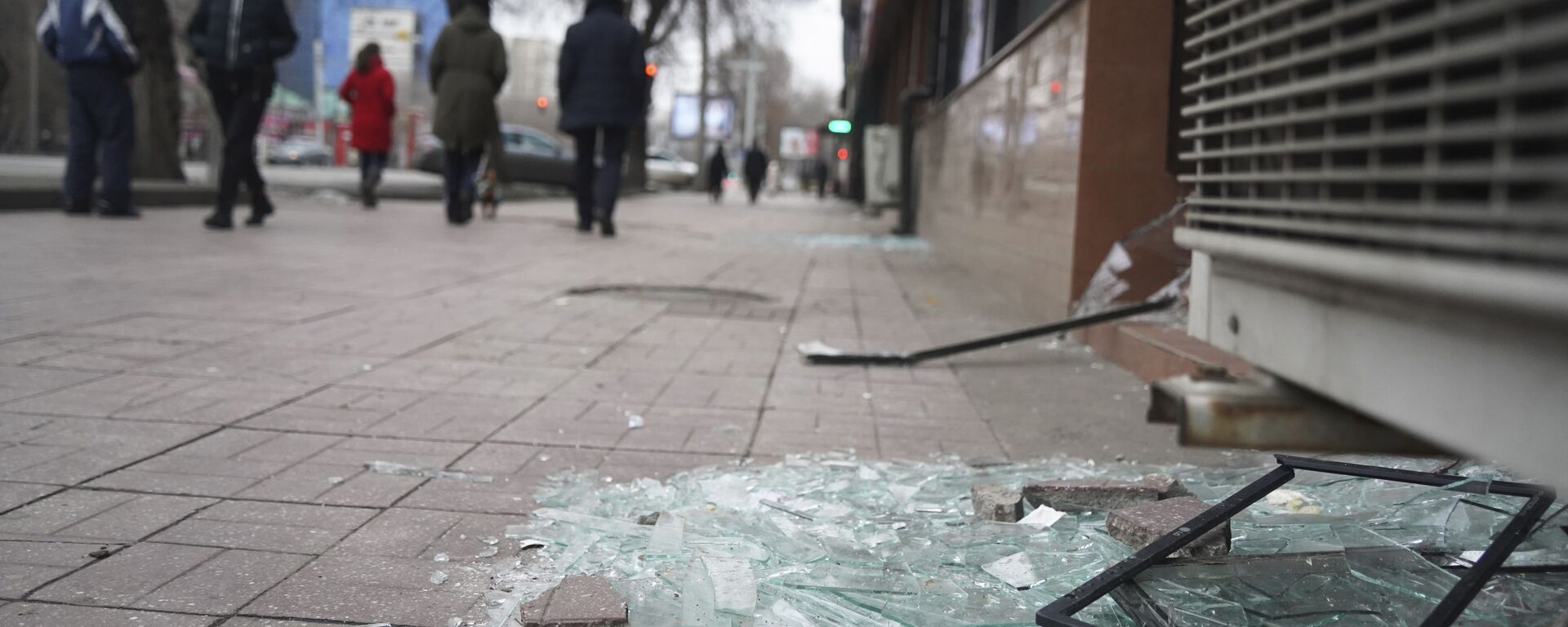 أشخاص يمشون أمام متجر به نوافذ مكسورة أثناء الاشتباكات في ألماتي، كازاخستان، 10 يناير 2022. - سبوتنيك عربي, 1920, 10.01.2022