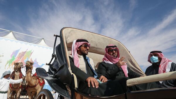 رجال إماراتيون يركبون عربة جمال خلال النسخة السادسة من مهرجان الملك عبد العزيز للإبل في منطقة رماح، على بعد 161 كلم شرق العاصمة الرياض،  8 يناير 2022 - سبوتنيك عربي
