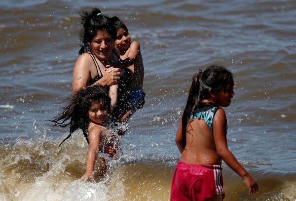 يستمتع الناس باليوم في نهر ريو دي لا بلاتا، خلال موجة الحر وسط ارتفاع حالات الإصابة بفيروس كورونا في بوينس آيرس، الأرجنتين 12 يناير 2022. - سبوتنيك عربي