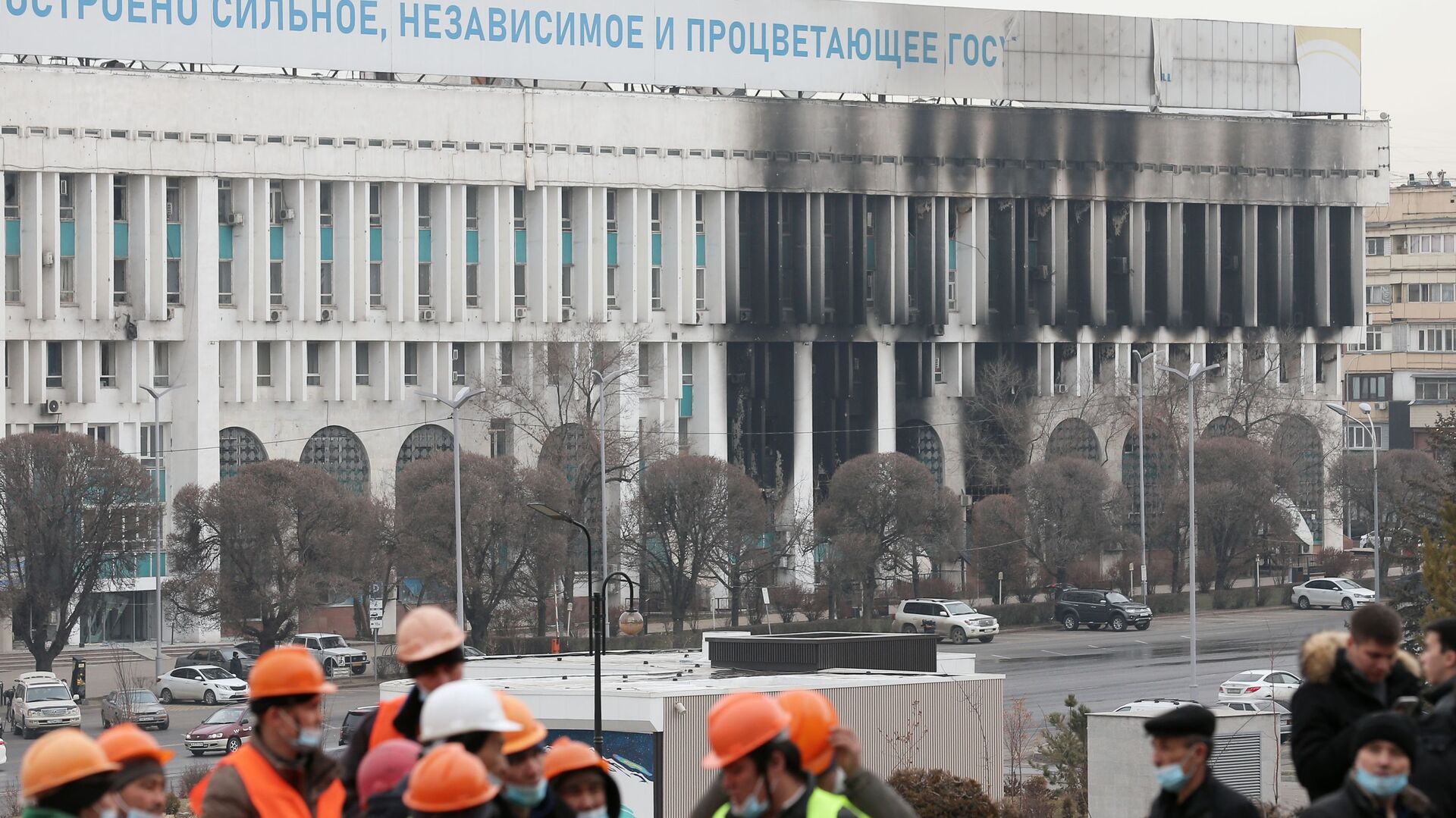 عمال على خلفية مبنى رئيس البلدية أكيمات الذي دمرته النيران في ألماتي، كازاخستان 13 يناير 2021 - سبوتنيك عربي, 1920, 19.01.2022