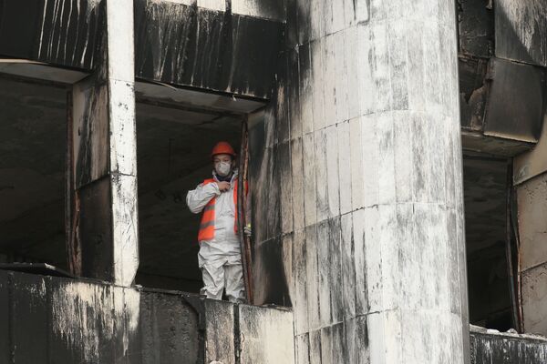 عامل خلال أعمال ترميم مبنى رئيس البلدية أكيمات الذي دمرته النيران في ألماتي، كازاخستان 13 يناير 2021 - سبوتنيك عربي