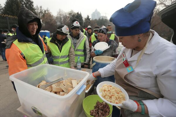 عمال خلال استراحة غداء بالقرب من مبنى رئيس البلدية أكيمات الذي دمرته النيران في ألماتي، كازاخستان 13 يناير 2021 - سبوتنيك عربي