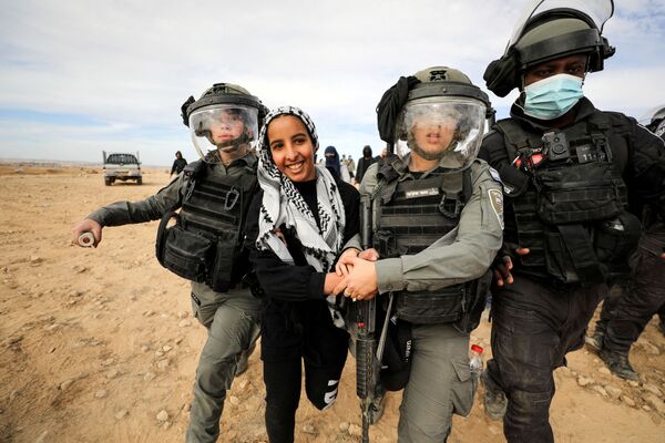 امرأة بدوية أثناء احتجازها من قبل قوات الأمن الإسرائيلية خلال مظاهرة ضد التشجير في قرية صاو الأطرش الصحراوية في النقب، جنوب إسرائيل، 12 يناير 2022. - سبوتنيك عربي