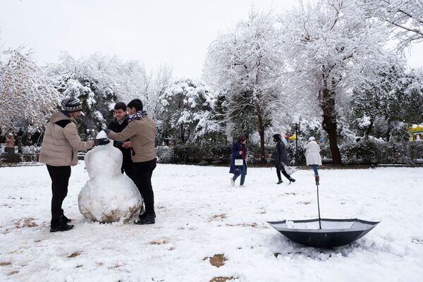 مواطنون يلعبون في حديقة مغطاة بالثلوج في السليمانية ويصنعون رجل الثلج، العراق ، 17 يناير 2022. - سبوتنيك عربي