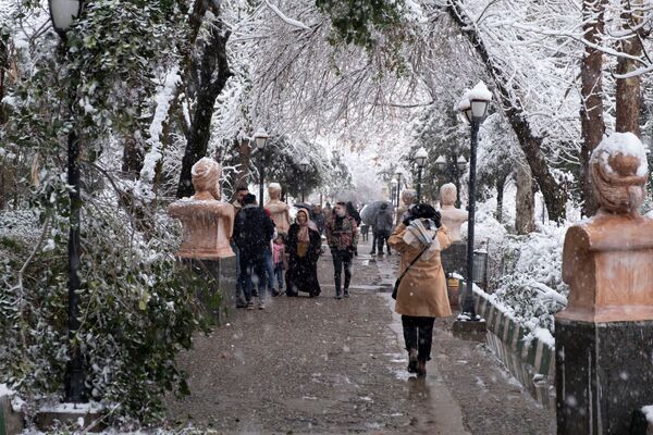 مواطنون يسيرون في حديقة مغطاة بالثلوج في السليمانية، العراق ، 17 يناير 2022. - سبوتنيك عربي