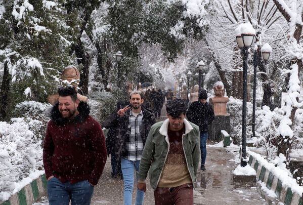 مواطنون يسيرون في حديقة مغطاة بالثلوج في السليمانية، العراق ، 17 يناير 2022. - سبوتنيك عربي