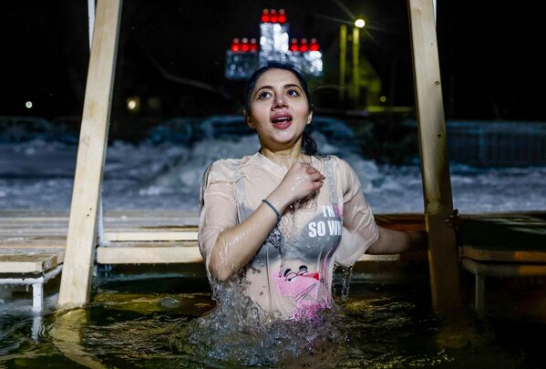 امرأة تغطس في المياه الجليدية خلال الاحتفالات بعيد الغطاس المسيحي الأرثوذكسي في بيرسلافل-زالسكي، منطقة ياروسلافل، روسيا، 18 يناير 2022. - سبوتنيك عربي
