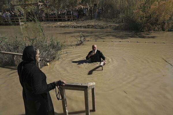 حاجّ مسيحي أرثوذكسي يغطس نفسه في نهر الأردن خلال مراسم التعميد كجزء من عيد الغطاس، بالقرب من بلدة أريحا بالضفة الغربية المحتلة، 18 يناير 2022 - سبوتنيك عربي