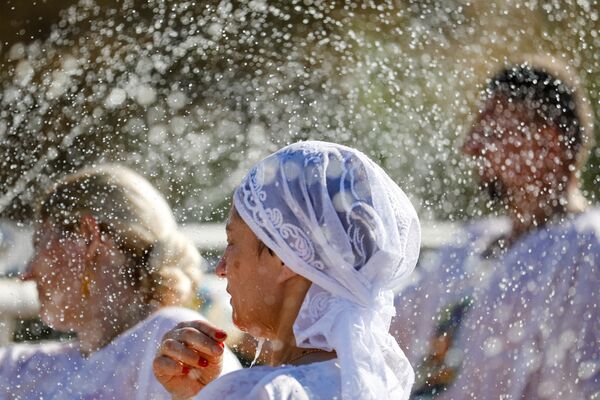 أحد المصلين يشارك في مراسم التعميد على ضفاف نهر الأردن للاحتفال بعيد الغطاس، فيما يُعتقد أنه موقع معمودية يسوع، بالقرب من أريحا في الضفة الغربية المحتلة 18 يناير 2022. - سبوتنيك عربي