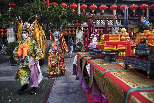 فنانو الأوبرا الصينية التقليدية من فرقة ساي يونغ هونغ (Sai Yong Hong) يتجولون بأزياءهم التقليدية حول المنطقة في مستودع لونغ 1919  في بانكوك، احتفالاً بالعام القمري الجديد القادم، 19 يناير 2022 - سبوتنيك عربي