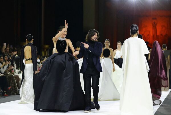 المصمم ستيفان رولاند وعارضة الأزياء نيفيس ألفاريز يظهران في نهاية عرض مجموعة &quot;هوت كوتور لربيع/ صيف 2022&quot; في باريس، فرنسا، 25 يناير 2022. - سبوتنيك عربي