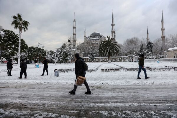 الناس يسيرون على خلفية مسجد السلطان أحمد، المعروف باسم المسجد الأزرق، أثناء تساقط الثلوج بغزارة في إسطنبول، تركيا، 25 يناير 2022. - سبوتنيك عربي