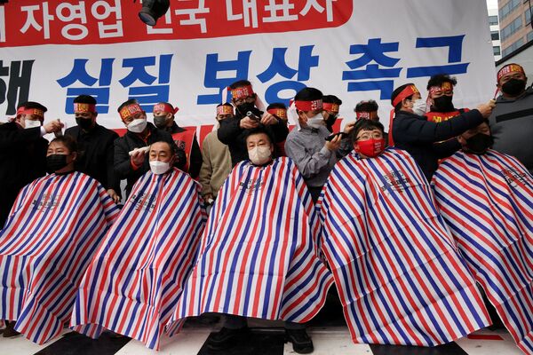 أصحاب الأعمال في كوريا الجنوبية يحلقون رؤوسهم خلال احتجاج على قواعد الحكومة الجديدة للتباعد الاجتماعي التي دخلت حيز التنفيذ في وقت سابق من هذا الشهر بالقرب من الجمعية الوطنية في سيؤل، كوريا الجنوبية، 25 يناير  2022. - سبوتنيك عربي