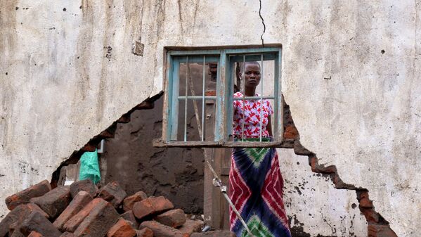 امرأة تنظر إلى منزلها الذي دمرته العاصفة الاستوائية آنا في قرية كانجدزا، في منطقة شيكواوا، جنوب ملاوي، 26 يناير  2022. - سبوتنيك عربي