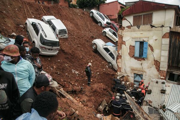 رجال الإطفاء يبحثون بين الأنقاض بعد انهيار موقف للسيارات يضم عدة سيارات خاصة على المنازل بعد هطول الأمطار الغزيرة في الأيام القليلة الماضية في حي أنكاديفوتسي في أنتاناناريفو، مدغشقر24 يناير 2022.  - سبوتنيك عربي
