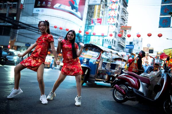 فتيات يرتدين أزياء صينية يرقصن قبل احتفالات رأس السنة القمرية الصينية الجديدة وسط تفشي مرض فيروس كورونا (كوفيد-19) في الحي الصيني في بانكوك، تايلاند ، 27 يناير  2022. - سبوتنيك عربي