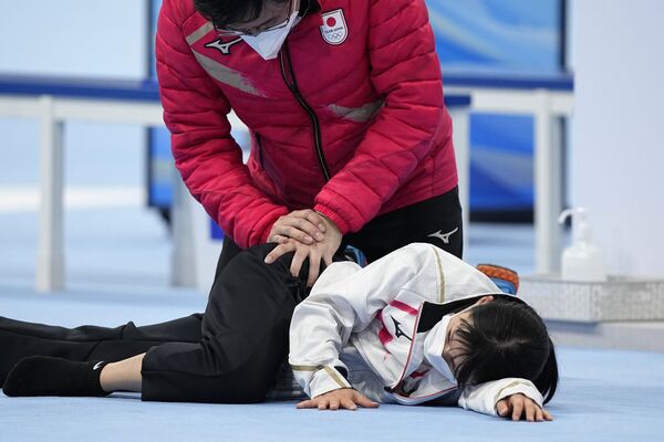 تتمدد اليابانية ميهو تاكاجي بمساعدة مدرب بينما تستعد للمنافسة في سباق التزلج السريع للسيدات لمسافة 1500 متر في دورة الألعاب الأولمبية الشتوية 2022، بكين، 7 فبراير  2022 . - سبوتنيك عربي