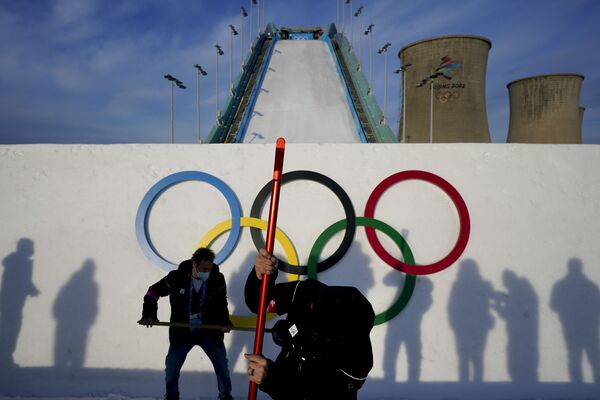 يعمل عاملان حول منحدر التزلج قبل جلسة تدريبية لمسابقة الهواء الكبيرة للتزلج الحر في الألعاب الأولمبية الشتوية 2022، بكين، 6 فبراير 2022. - سبوتنيك عربي