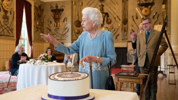 ملكة بريطانيا إليزابيث الثانية تقطع كعكة للاحتفال ببدء اليوبيل البلاتيني خلال حفل استقبال في قاعة الاحتفالات في ساندرينغهام هاوس، مقر إقامة الملكة في نورفولك في 5 فبراير 2022. - سبوتنيك عربي