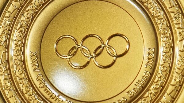رياضي روسي يحمل ميدالية ذهبية خلال حفل توزيع جوائز المراكز الثلاثة الأولى في سباق التتابعي للرجال 4x10 كم على الثلج، في الدورة الرابعة والعشرين للألعاب الأولمبية الشتوية 2022. - سبوتنيك عربي