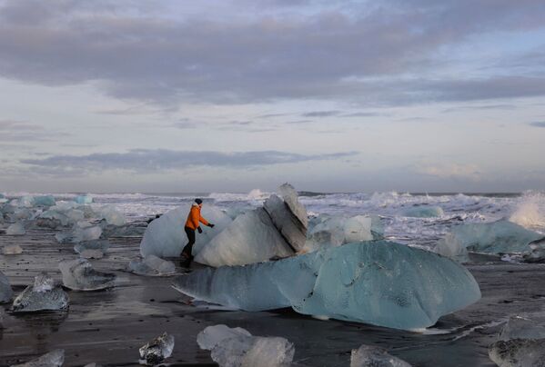 سياح يزورون كتل الجليد التي قطعت بحيرة جوكولسارلون الجليدية على شاطئ دايموند خلال فصل الشتاء في الساحل الجنوبي لأيسلندا، 17 فبراير 2022. - سبوتنيك عربي