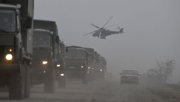 رتل شاحنات وطائرة هليكوبتر هجومية من طراز مي-24 تابعة للقوات الجوية الروسية في أرميانسك، 25 فبراير 2022 - سبوتنيك عربي