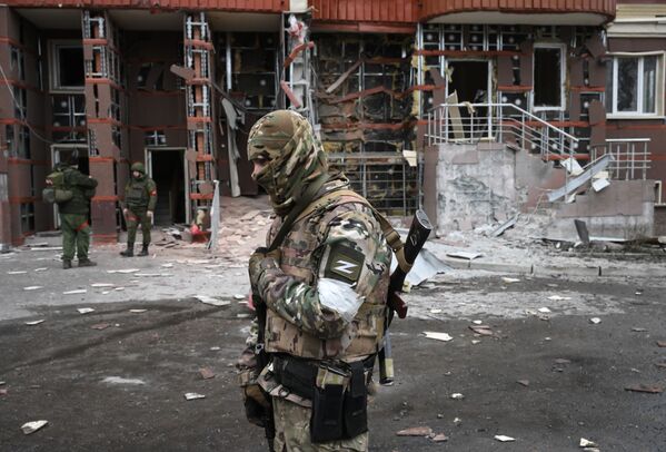 جنود تابعون لقوات دونيتسك الشعبية في فناء مبنى سكني متعدد الطوابق في مدينة دونيتسك  تضرر من جراء القصف الأوكراني 28 مارس 2022 - سبوتنيك عربي