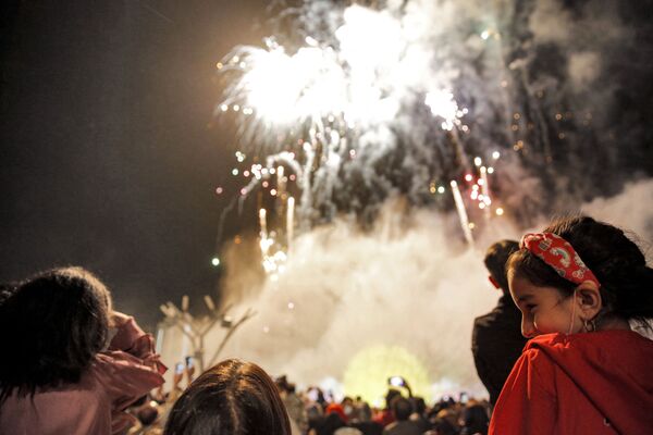 الناس يشاهدون الألعاب النارية تضيء السماء أثناء حضورهم حفل للاحتفال بعيد نوروز، رأس السنة الفارسية ، في مركز تسوق إيران مول في العاصمة الإيرانية طهران، إيران 20 مارس 2022. - سبوتنيك عربي