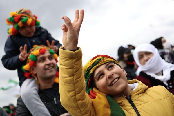 الحاضرون يرفعون أصابعهم في لافتة سلام خلال احتفال النوروز، الذي يصادف قدوم الربيع، في إسطنبول، تركيا، 20 مارس 2022. - سبوتنيك عربي