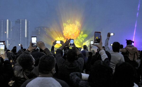 يستخدم الناس هواتفهم للتصوير أثناء احتفال بعيد النوروز، رأس السنة الفارسية، في مركز تسوق إيراني في العاصمة الإيرانية طهران،  إيران 20 مارس 2022. - سبوتنيك عربي